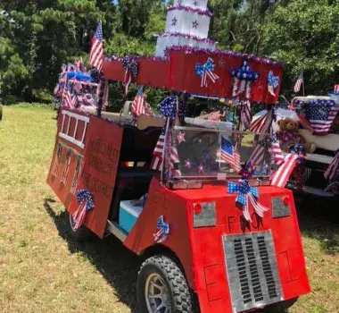 A golf cart decorated as a fire truck with american flags.