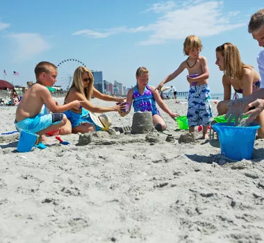Family on beach building sandcastle